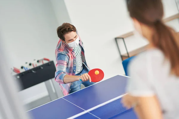 Couple of students wearing masks while playing table tennis in the campus — Stock Photo, Image