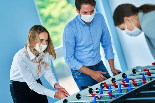 Business people wearing masks relaxing in shared office space