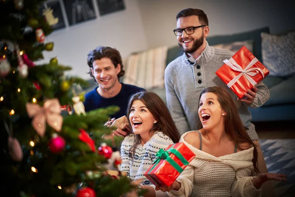 Groupe d'amis avec des cadeaux célébrant Noël à la maison — Photo