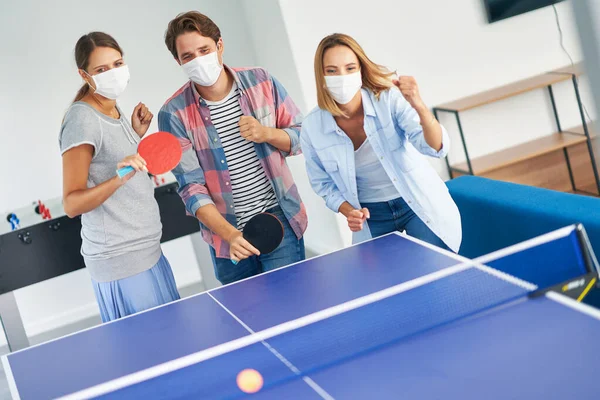 Group of students wearing masks playing table tennis in the campus — Stock Photo, Image