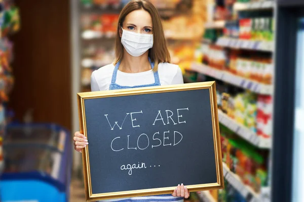 Shop assistant holding announcement board — Stock Photo, Image