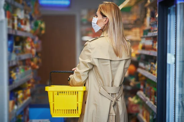 戴着医疗面罩的成年妇女采购食品杂货 — 图库照片