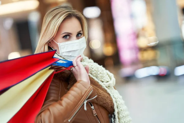 Portrait of adult woman shopping in mall wearing a mask, coronavirus concept — Stock Photo, Image