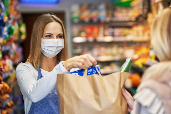 Mulher adulta em máscara médica pegando ordem no supermercado — Fotografia de Stock