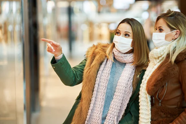 Portrait of two friends shopping together wearing a mask, coronavirus concept — Stock Photo, Image