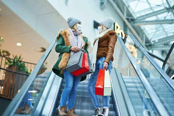 Retrato de dois amigos comprando juntos usando uma máscara, conceito coronavírus — Fotografia de Stock