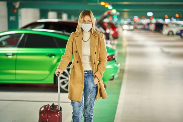 在地下机场停车场戴口罩的成年女性游客 — 图库照片