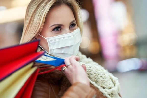 Portrait of adult woman shopping in mall wearing a mask, coronavirus concept — Stock Photo, Image