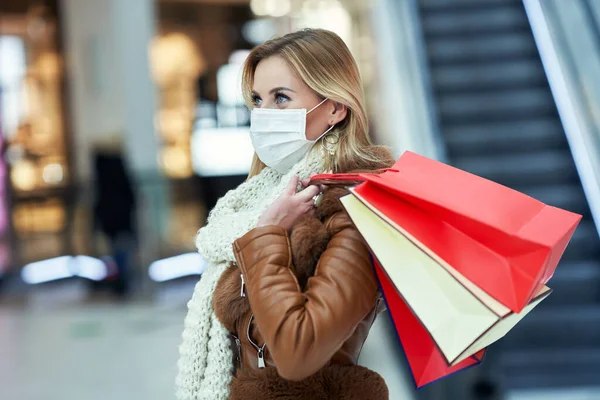 Retrato de mulher adulta fazendo compras em shopping usando uma máscara, conceito de coronavírus — Fotografia de Stock