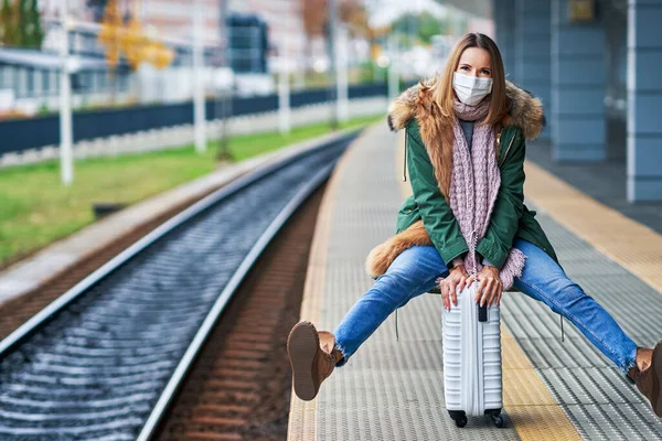 Volwassen vrouw op het station met maskers als gevolg van covid-19 beperkingen — Stockfoto