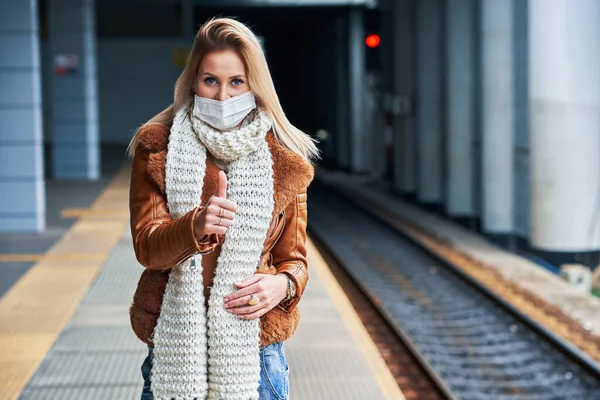 Mulher adulta na estação de trem usando máscaras devido a restrições covid-19 — Fotografia de Stock