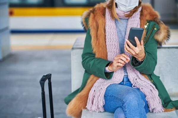 Volwassen vrouw op het station met maskers als gevolg van covid-19 beperkingen — Stockfoto