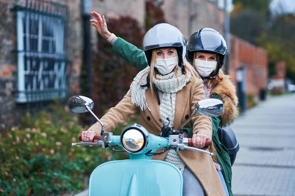 Dwie kobiety w maskach i dojeżdżające na skuterze — Zdjęcie stockowe