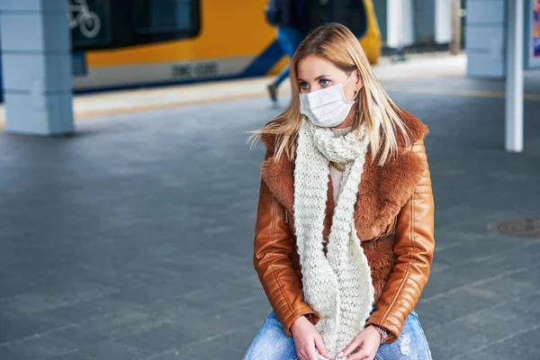 Adult woman at train station wearing masks due to covid-19 restrictions — Stock Photo, Image