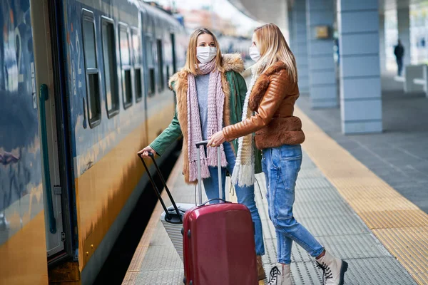 Duas mulheres na estação de trem usando máscaras devido a restrições covid-19 — Fotografia de Stock