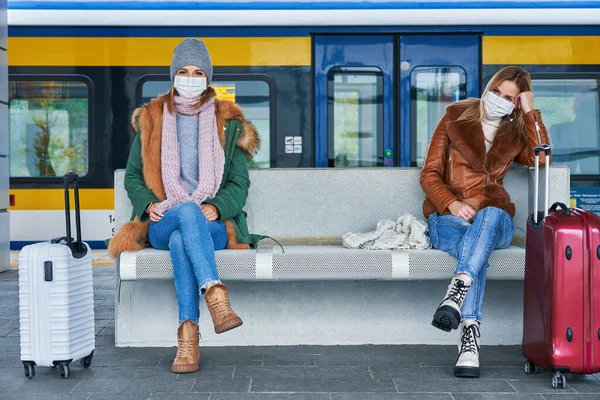 Duas mulheres na estação de trem usando máscaras devido a restrições covid-19 — Fotografia de Stock