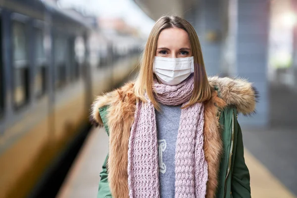 Mulher adulta na estação de trem usando máscaras devido a restrições covid-19 — Fotografia de Stock