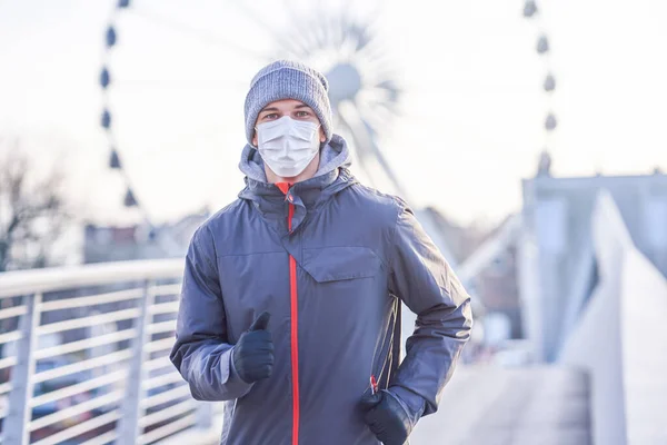 Hombre adulto corriendo en la ciudad con máscaras durante el encierro —  Fotos de Stock