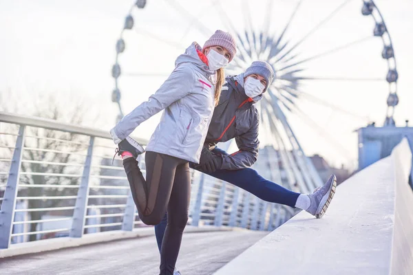 Adult couple jogging in the city in masks during lockdown — Stock Photo, Image