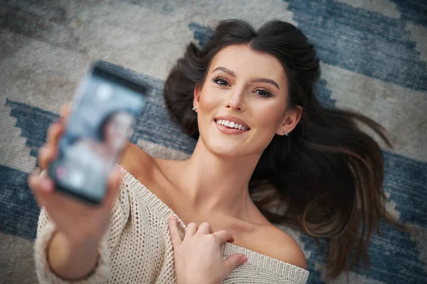 Mladá sexy žena relaxaci doma pomocí smartphonu — Stock fotografie