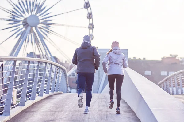 Pasangan dewasa jogging di kota dalam topeng selama kuncian — Stok Foto