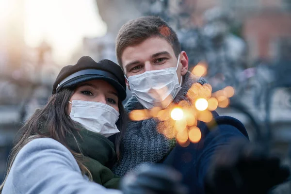 Casal feliz comemorando o Dia dos Namorados em máscaras durante a pandemia de 19 anos — Fotografia de Stock