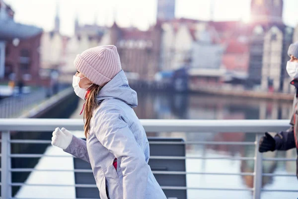 Erwachsene Frau joggt während Sperrung maskiert in der Stadt — Stockfoto
