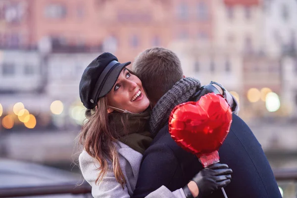 Pareja feliz celebrando el Día de San Valentín con máscaras durante la pandemia de covid-19 —  Fotos de Stock