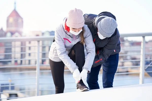 Dospělí pár jogging ve městě v maskách během uzamčení — Stock fotografie