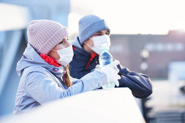 Adult couple jogging in the city in masks during lockdown — Stock Photo, Image