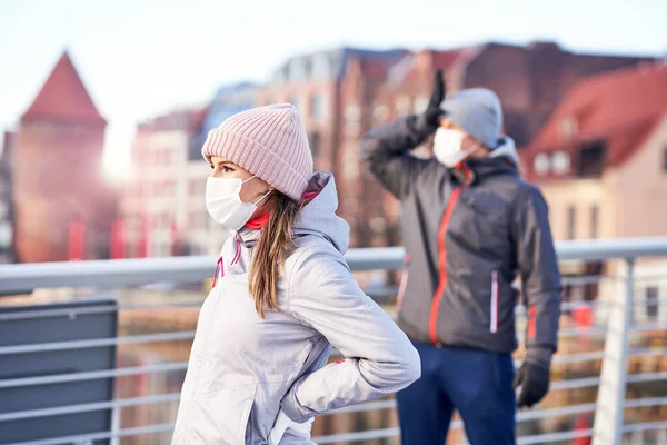 Adulto casal correndo na cidade em máscaras durante bloqueio — Fotografia de Stock