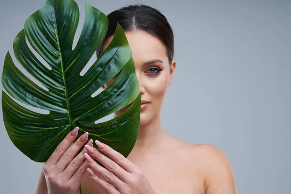 Portret van een mooie vrouw op een grijze achtergrond — Stockfoto