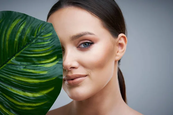 Portret van een mooie vrouw op een grijze achtergrond — Stockfoto