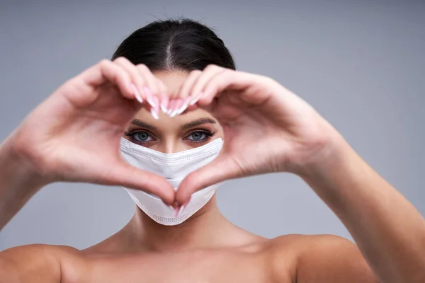 Porträt der schönen Frau in Maske auf grauem Hintergrund — Stockfoto