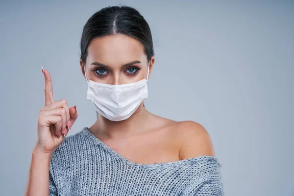 Porträt der schönen Frau in Maske auf grauem Hintergrund — Stockfoto