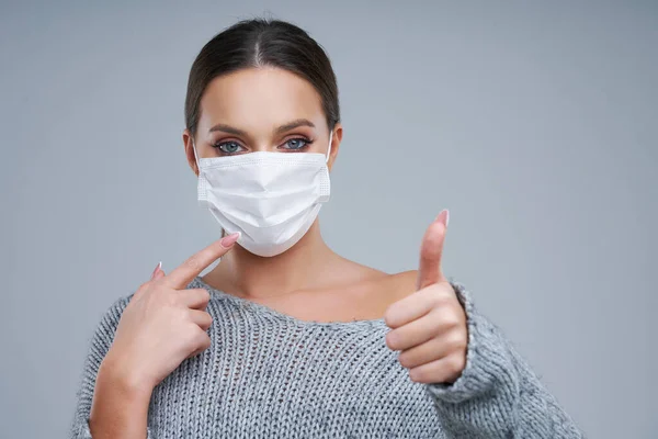 Portrait of beautiful woman in mask on gray background — Stock Photo, Image