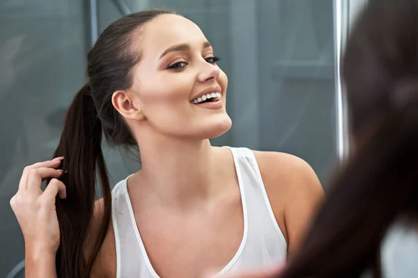 Frau blickt nach Dusche auf Spiegelung im Spiegel — Stockfoto