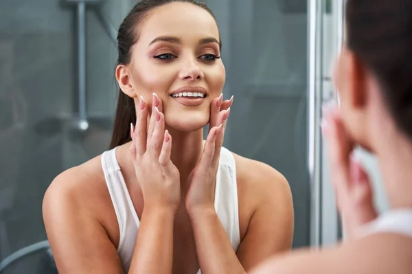 Mujer mirando a la reflexión en el espejo después de la ducha — Foto de Stock