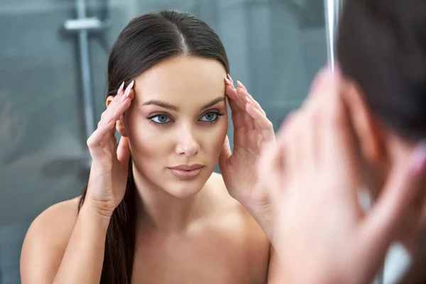 Mujer mirando a la reflexión en el espejo después de la ducha — Foto de Stock