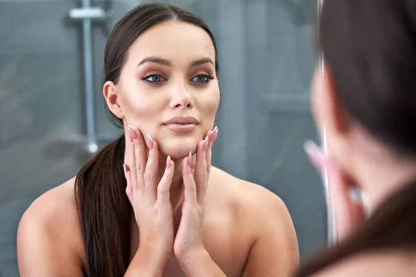 Mujer mirando a la reflexión en el espejo después de la ducha — Foto de Stock