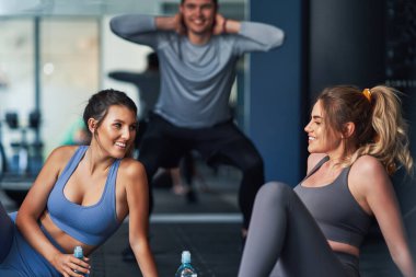 Spor salonunda çalışan bir grup insan.