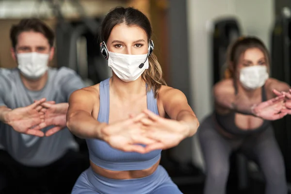 Group of people wearing masks working out in a gym