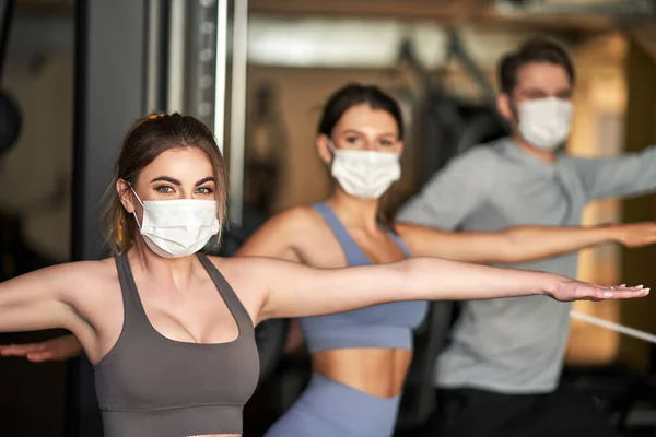 Group of people wearing masks working out in a gym