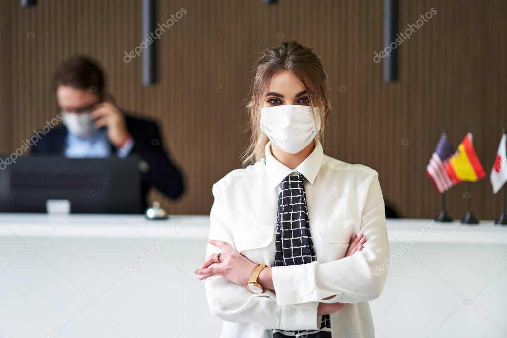 Receptionist wearing mask working in a hotel