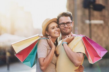Şehirde alışveriş torbalı mutlu bir çift.