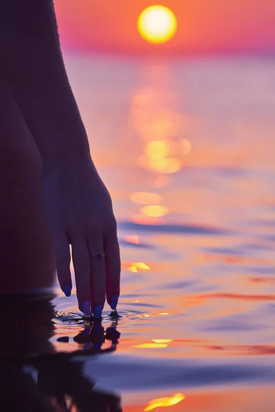Silhuett av ung kvinna som utövar yoga på stranden vid soluppgången — Stockfoto