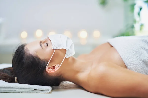 Vuxen kvinna i mask under avkopplande massage i spa — Stockfoto