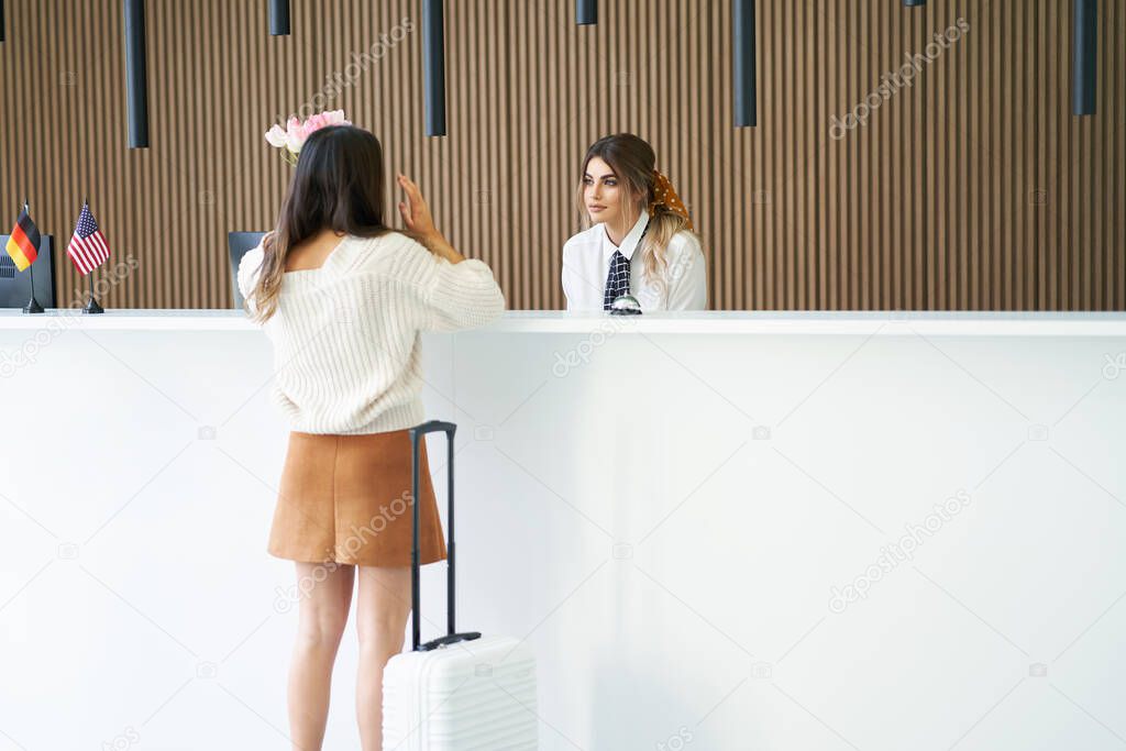 Female tourist waiting at reception desk in hotel