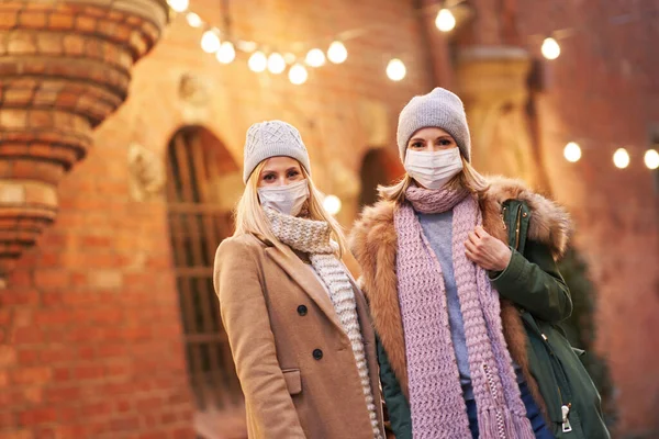 Duas mulheres usando máscaras e saindo na cidade — Fotografia de Stock