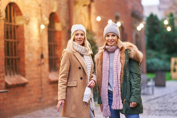 Dos mujeres con máscaras faciales y pasando el rato en la ciudad — Foto de Stock